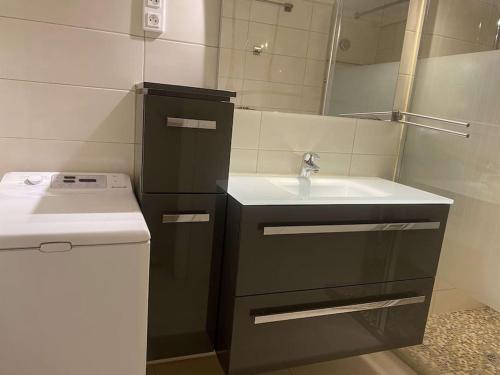 une petite salle de bain avec un lavabo et un miroir dans l'établissement Le MONDAIN - Studio Palais des festivals-Front Mer, à Cannes