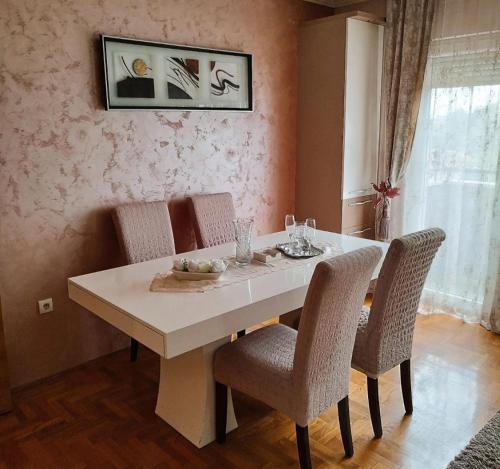 mesa de comedor con 2 sillas y mesa blanca en Family Star apartman en Čačak