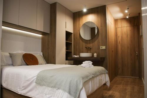 a bedroom with a large white bed and a mirror at Suite JC1 CHIC in Murcia