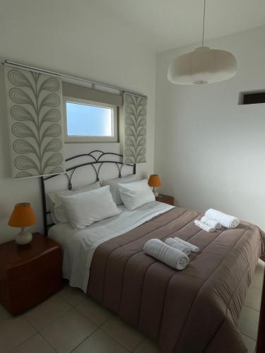 - une chambre avec un grand lit et 2 serviettes dans l'établissement House Blue Roses Apartment Step Up in Puglia for your Niksen, à Bari