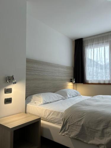 a bedroom with a large bed and a window at Jolly Resort & SPA in Ponte di Legno