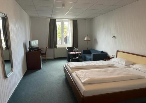 ルターシュタット・アイスレーベンにあるMansfelder Hofのベッドと椅子付きのホテルルーム