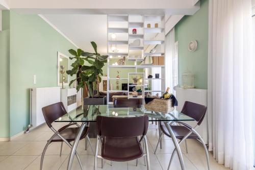 a dining room with a glass table and chairs at Aurora Urban Condo in Heraklio Town