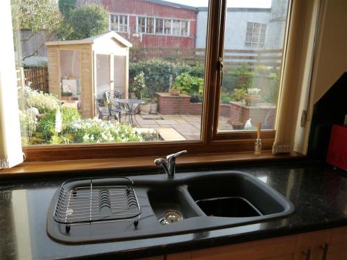 a kitchen sink and a window with a view of a garden at Number 48 in Dumfries