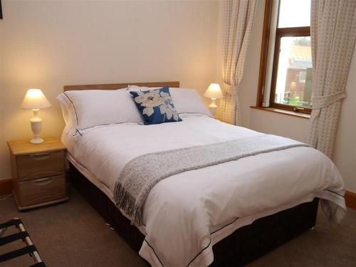 a bedroom with a large bed with a window at Number 48 in Dumfries