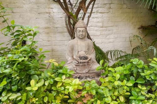 a statue sitting in front of a wall at Stay Banaras - A Boutique Hotel in Varanasi