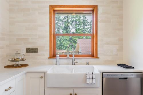 eine Küche mit einem Waschbecken und einem Fenster in der Unterkunft Camano Vista Paradise by AvantStay Private Beach in Greenbank
