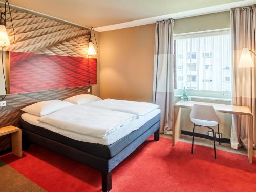 フランクフルト・アム・マインにあるB&B Hotel Frankfurt-Messeのベッドとデスクが備わるホテルルームです。