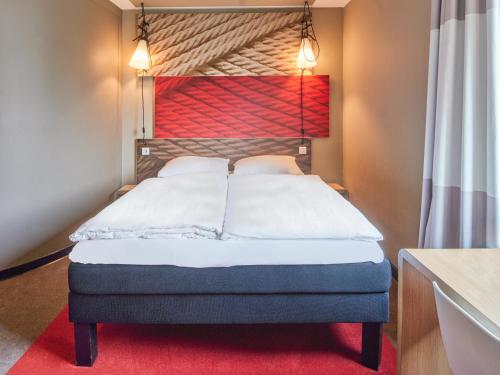 a bedroom with a bed with a red headboard at B&B Hotel Frankfurt-Messe in Frankfurt/Main