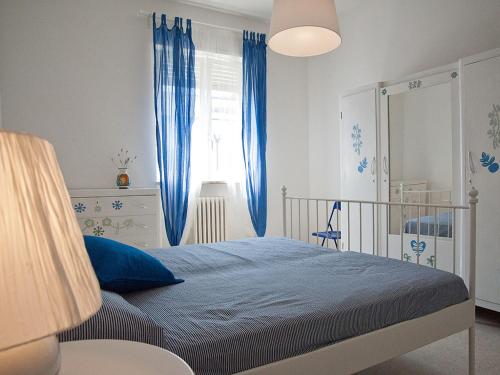 a bedroom with a bed with blue curtains and a window at B&B Alcione in Pescara