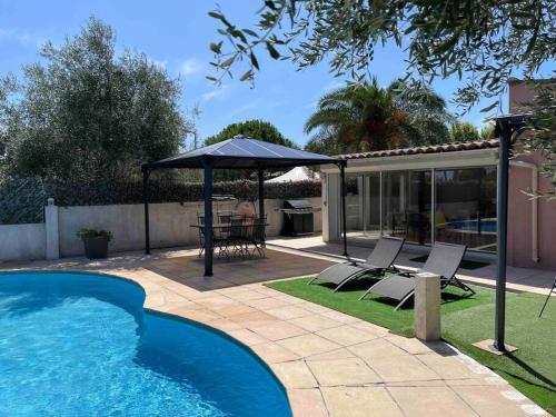 une cour arrière avec une piscine et un gazebo dans l'établissement Villa climatisée piscine 3 chambres mer à 800m, à Antibes