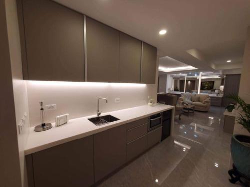a kitchen with a sink and a living room at Luxury Suite in BF Homes in Manila