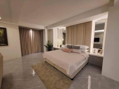 ein Schlafzimmer mit einem großen Bett in einem Zimmer in der Unterkunft Luxury Suite in BF Homes in Manila