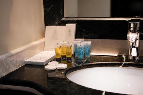 a bathroom counter with a sink and glasses on it at Ewan Dar Alhejra Hotel in Al Madinah