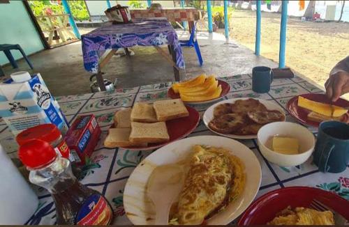 a table with plates of breakfast food on it at Jaymy Beach Fales in Apia