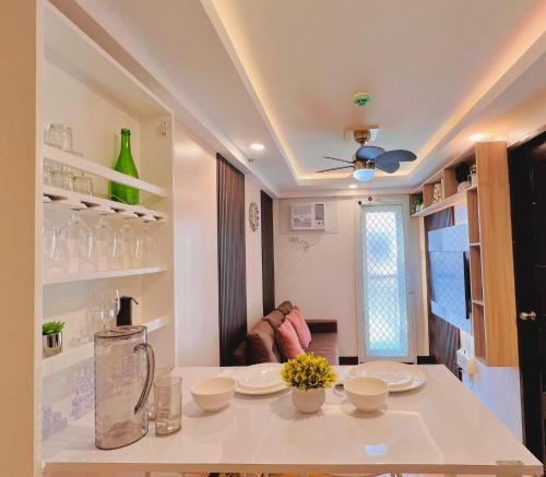 a kitchen with a counter with bowls and flowers on it at AJ’s Cozy Condo Davao in Davao City