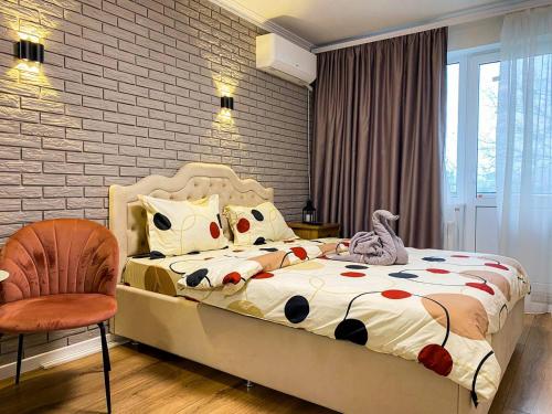 une chambre avec un lit et une chaise dans l'établissement Sunny Apartment, à Chişinău