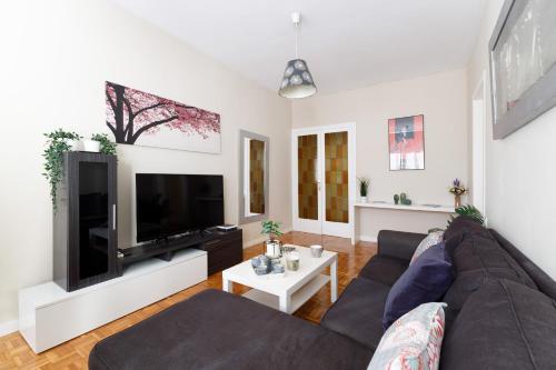 a living room with a couch and a flat screen tv at Mercat Sant Antoni 4 in Barcelona