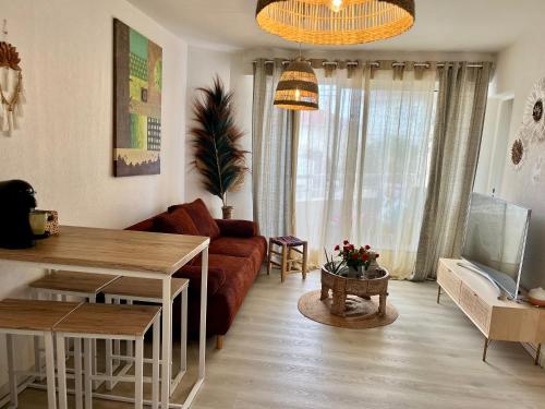 een woonkamer met een bank en een tafel bij Appartement vue océan in Capbreton