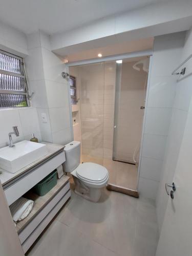 a bathroom with a toilet and a sink and a shower at Studio reformado - sem garagem de auto in São Vicente