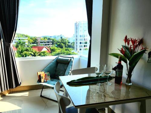 uma mesa de jantar com copos de vinho e uma janela em Mi Amor Luxury Island Apartment - 3 minutes to the beach em Duong Dong