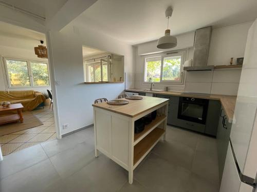 - une cuisine avec un comptoir et une cuisinière four supérieur dans l'établissement La Maison du Courant 3*, à Mimizan