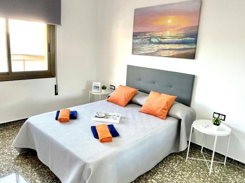 レウスにあるAPARTBEACH EL CARRILET CENTRICO y LUMINOSOのベッドルーム1室(オレンジと青の枕が付いたベッド1台付)