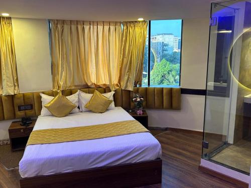a bedroom with a bed and a large window at Hotel Air Stay Inn - Andheri East in Mumbai