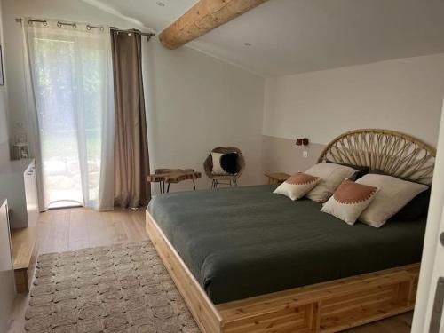 a bedroom with a large bed and a large window at Villa des jacinthes in Tarascon
