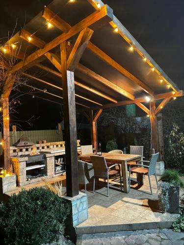 a wooden pergola with a wooden table and chairs at Ранчо, Дом для релакса в окружении леса и озёр in Kolonshchina