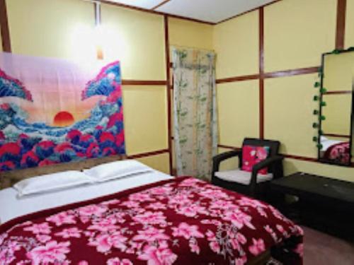 a bedroom with a large bed with a pink blanket at Nature's Hub Homestay Pasighat in Pāsighāt