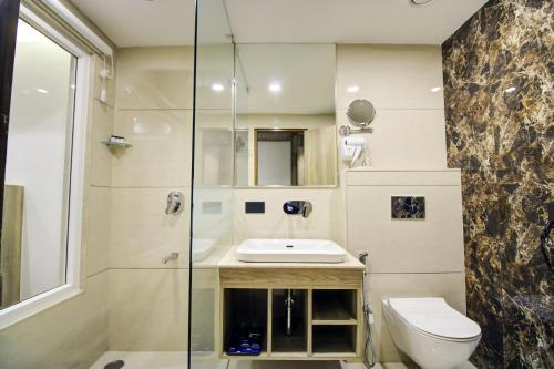 a bathroom with a toilet and a sink and a shower at Cygnett Style Ganga in Jaipur