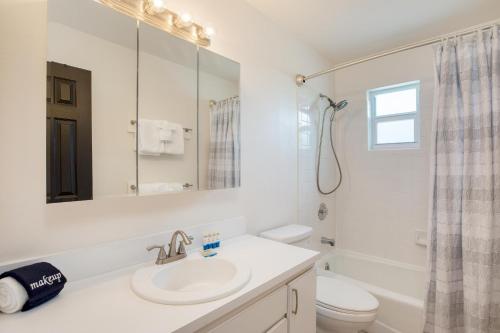 Baño blanco con lavabo y aseo en Sea Glass Secrets by AvantStay 3 Mins to Beach, en Key West