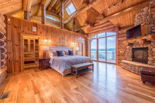 een slaapkamer in een blokhut met een bed en een open haard bij Azalea Retreat- The Lodge by AvantStay Best View in Lake Norman of Catawba