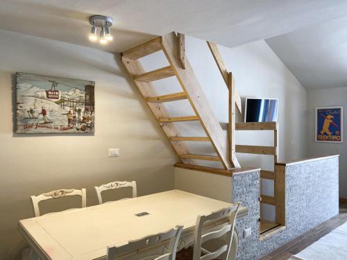 comedor con mesa y escalera de caracol en Fiocco di Neve Home, en Passo del Tonale