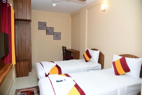een hotelkamer met 2 bedden en een televisie bij 1 RK AC Room with Open Terrace Manyata Tech Park in Bangalore
