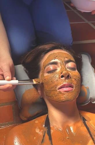 a woman getting a face mask with a brush at Monarca Azul Glamping in Villa de Leyva