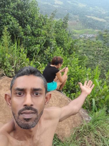 a man sitting on a rock next to a woman at City View Hostel in Kandy