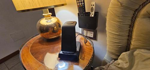 a table with a lamp and a remote control on it at Milan Condo ideal for Families,Pets,Business in Milan
