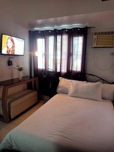 1 dormitorio con 1 cama blanca y TV de pantalla plana en Cozy House, en Apaleng