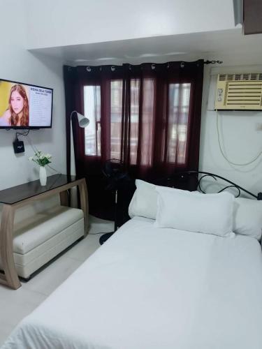 1 dormitorio con 2 camas blancas y TV en Cozy House, en Apaleng