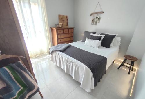 a bedroom with a large bed and a chair at Acogedor apartamento en EL VALLE DEL JERTE 1 in Piornal
