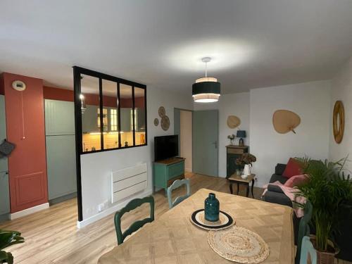 a living room with a table and a room with a couch at Appartement familial 8 personnes proche de Disney et Paris in Chessy