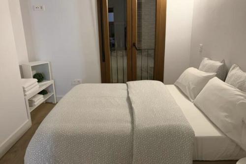 a bedroom with a bed with white sheets and pillows at AnDiMi Don Diego in Toledo