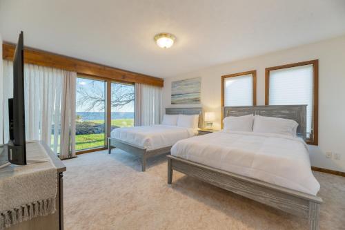 a bedroom with two beds and a flat screen tv at Bay Cottage by AvantStay Waterfront Pier Pond in Ridge