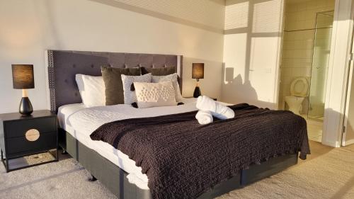 Un dormitorio con una cama grande y dos lámparas. en Mega Style Apartments Capri, en Melbourne