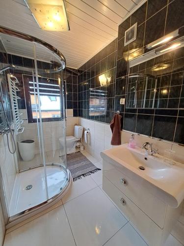 a bathroom with a shower and a sink at Pokoje gościnne U Paliderki in Poronin