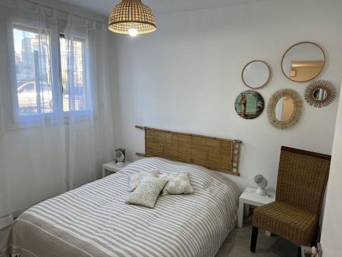 - une chambre avec un lit, une chaise et des miroirs dans l'établissement APPARTEMENT RENOVE T4 - 6 PERSONNES AVEC PARKING ET JARDIN, au Grau-du-Roi