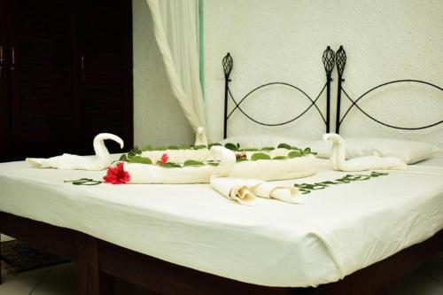 a bed with swans on it with flowers on it at Seaview Resort Malindi in Malindi