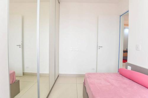 a bedroom with a pink bed and a mirror at champs frente mar ao sol in Balneário Camboriú